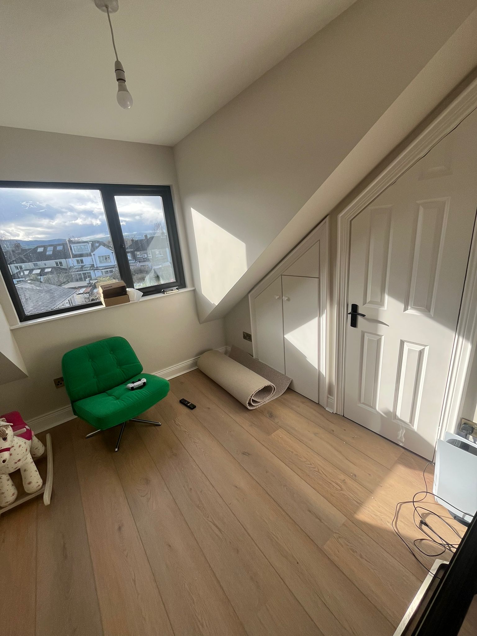 Attic dormer bedroom with sloped ceiling, black-framed window, wooden floors and eaves storage