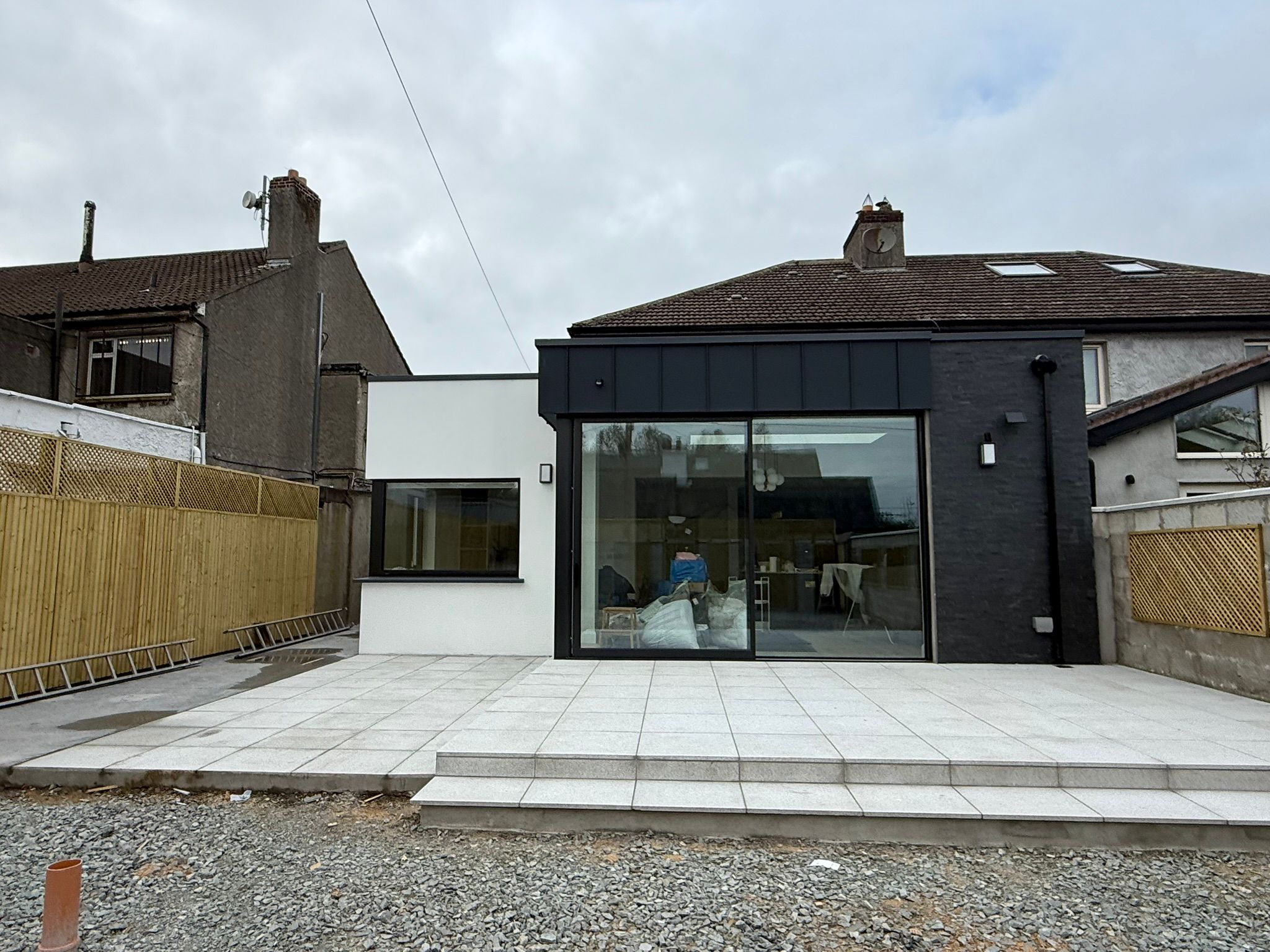 Rear house extension with large black-framed glass sliding doors and patio